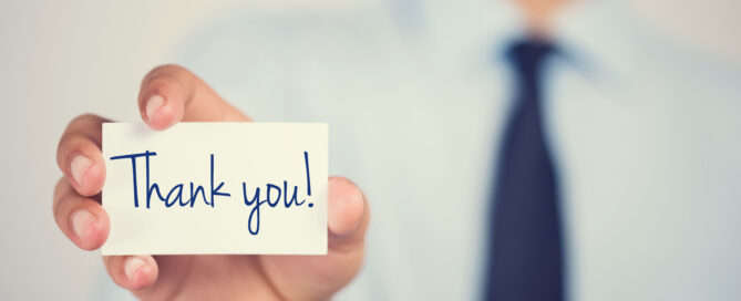 Thank you word on card hold by man